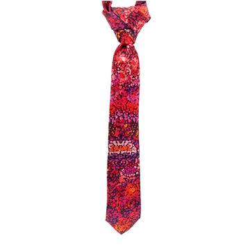 A tie is hanging and printed with artwork by Andrea Mimitja Adamson in shades of red and pink.