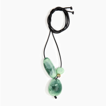 A necklace with large moss green resin beads on a black cord.