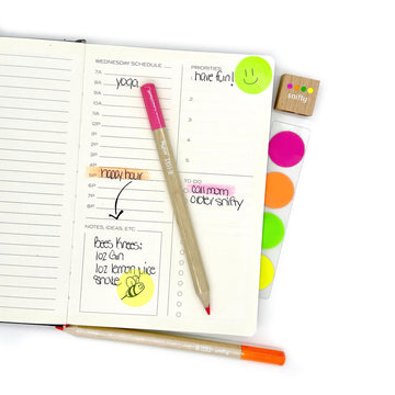 A set of four highlighter wooden pencils with round sticky notes and a sharpener.