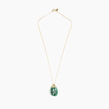A gold necklace with a moss green pendant.