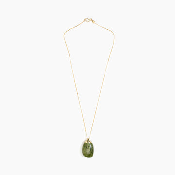 A gold necklace with an olive green pendant.