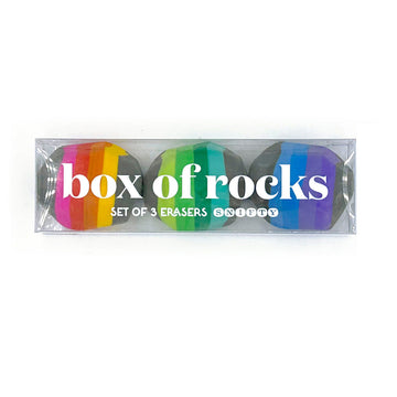 A clear box filled with three striped erasers shaped like rocks.