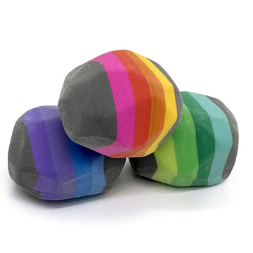 A clear box filled with three striped erasers shaped like rocks.