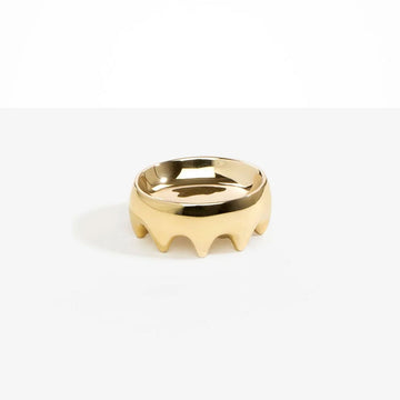 A brass bowl with multiple legs on the bottom.