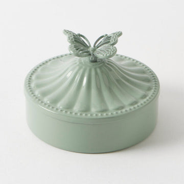 Mint green ceramic dish with butterfly handle on a white background.