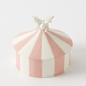 Pink and white striped trinket box with a white bee handle on a light gray background.