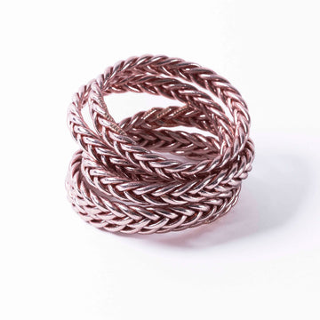 A stack of braided bracelets in rose gold.