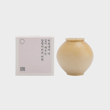Beige ceramic jar of soap with a box on a light gray background.