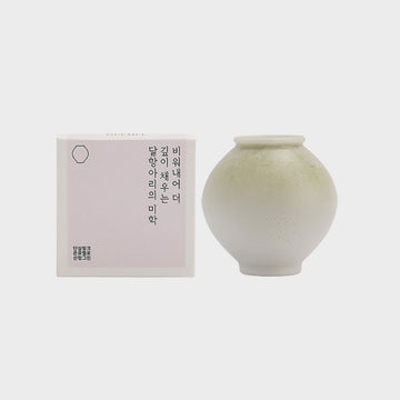 Green soap shaped like a vase and packaging with text on a light gray background.