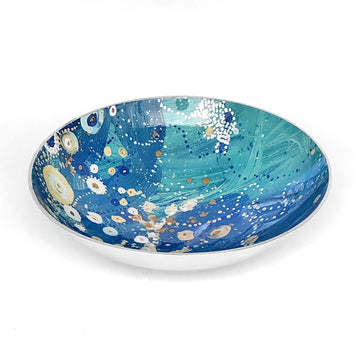 A round salad bowl in silver with artwork by Stephen Nelson on the inner side.