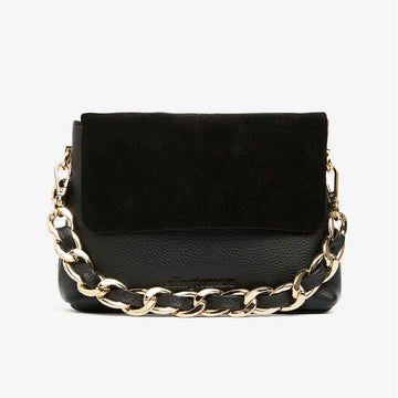 A small black bag with a suede flap over the leather bag. It also has a short gold chain strap.