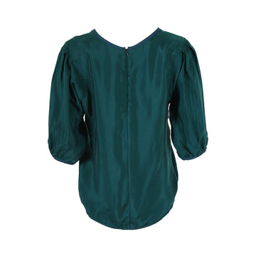 Front view of a teal green blouse with half length gathered sleeves.