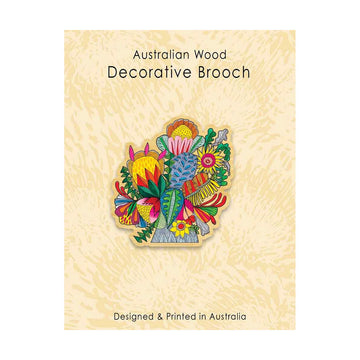 A wooden brooch printed with a colourful flower bouquet on card backing.