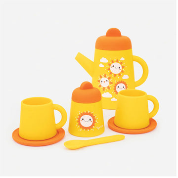 A silicone tea set in orange and yellow featuring images of suns on the items. There is a tea pot, two cups and a sugar bowl.
