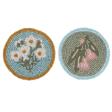 A set of two beaded coasters with floral designs.