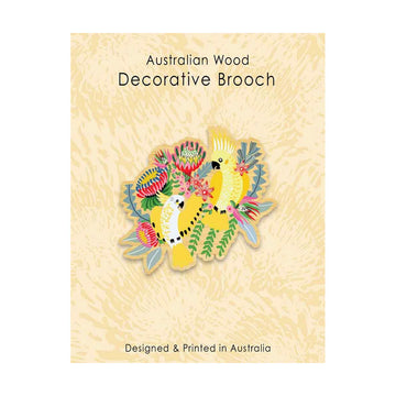Decorative brooch with floral and cockatoo design on a beige background, labeled 'Australian Wood Decorative Brooch'.