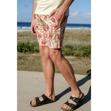 Close up front view of a man wearing botanical floral printed shorts.