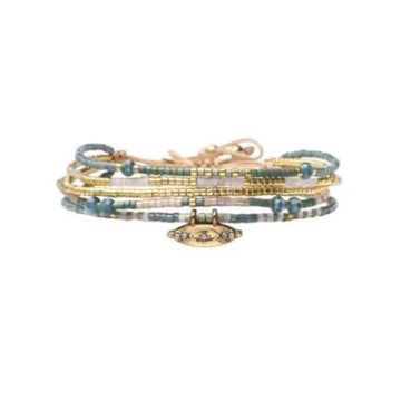 Stack of beaded bracelets with a central evil eye charm on a white background.