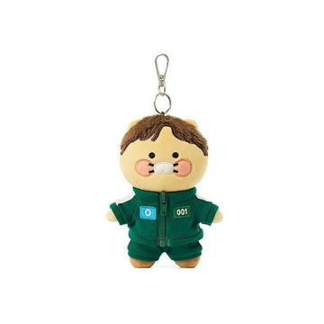 Plush keychain of a character in a green outfit with a blue patch on a white background.
