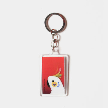 A rectangle keyring with a moving image of a cockatoo against a red background.