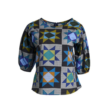 A women's blouse in grey printed with star shapes in blue and orange.