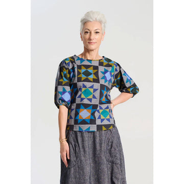 A women's blouse in grey printed with star shapes in blue and orange.