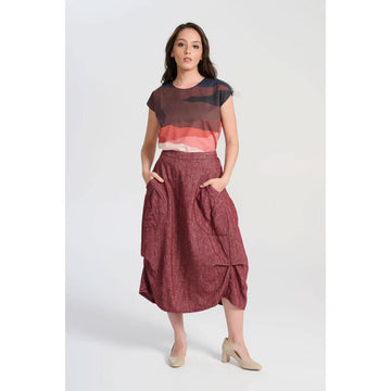 A dark dusty pink skirt with side pockets and side tucks.