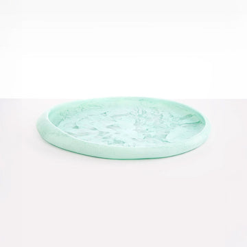 A large round resin tray in mint green.
