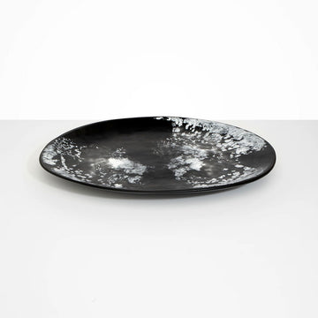 A large round platter in black marble resin.