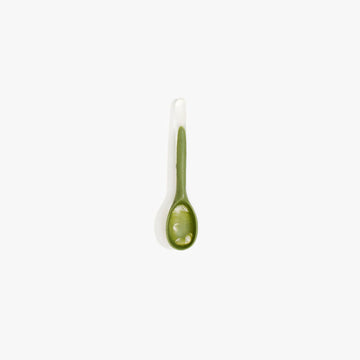 A small spoon made from olive green resin.