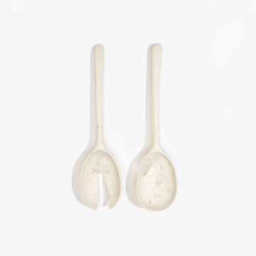 A pair of salad servers made from cream coloured resin.