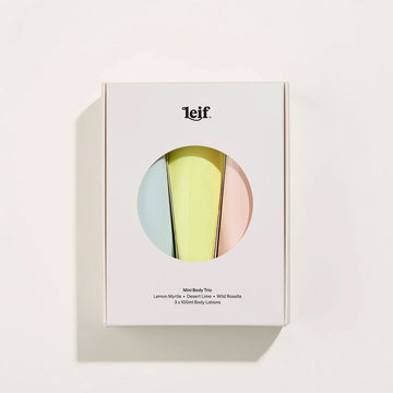A white box with a circle cut out on the front with three pastel coloured tubes of body lotion.