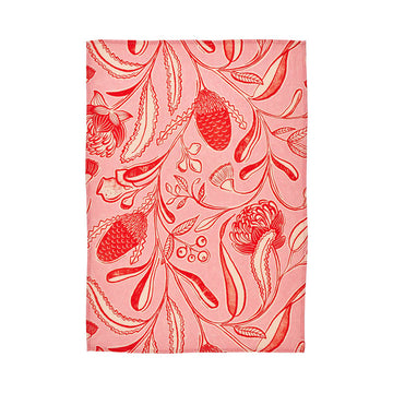 Floral patterned tea towel with red and white design on a pink background