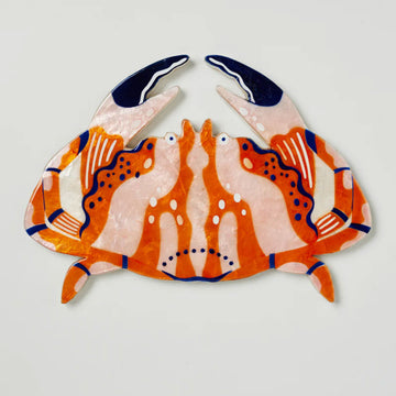 A piece of wall art shaped like an orange crab.