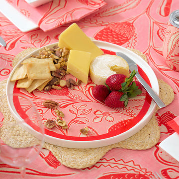 Decorative plate with red floral pattern on a white background.