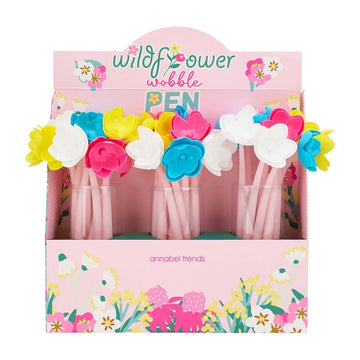 Packaged set of floral pens with 'wildflower wobble pen' branding on a pink background.