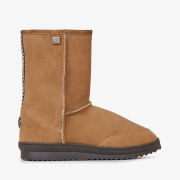 Tan suede boot with a black sole on a white background.