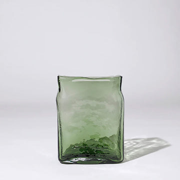 A irregular shaped square vase in green glass.