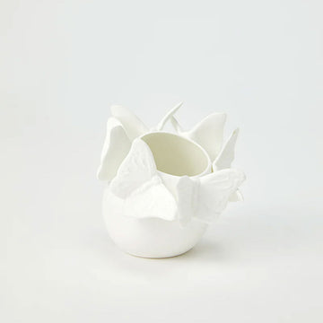A small ceramic white vase with 3D butterflies around the top edge.