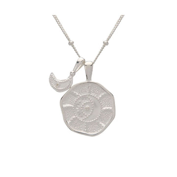 A silver necklace with a rounded pendant and a smaller crescent moon pendant on a silver chain.