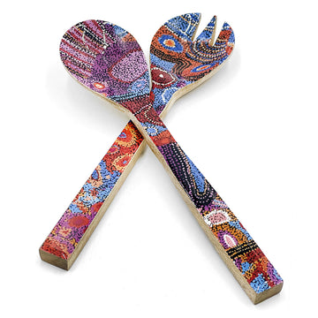 A pair of wooden salad servers printed with artwork by Andrea Mimpitja Adamson on the front.