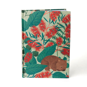 A hardcover journal illustrated with a wombat surrounded by red flowers and leaves.