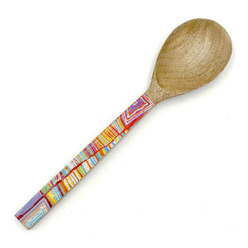 A wooden serving spoon printed with artwork by Judy Watson on the front.