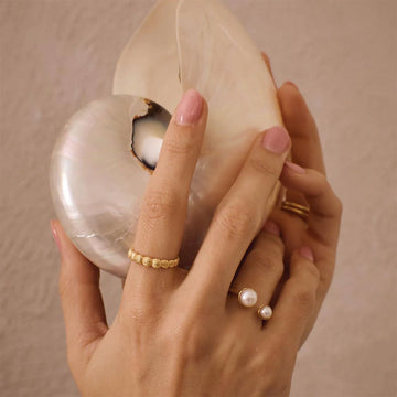 A gold ring with overlapping shell shapes.