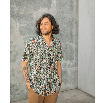 Front view of a model wearing a short sleeve shirt illustrated with flowers.