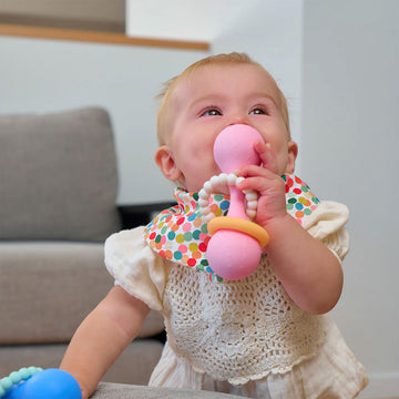 Pink and orange teething ring attached to a silicone dumbbell.