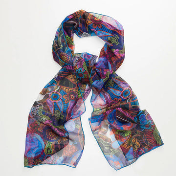 A sheer scarf printed with artwork by Justin Butler and loosely tied in a knot.