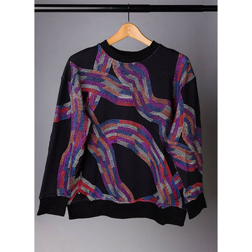 A black jumper with colourful wavy lines featuring artwork by Flora Brown is hanging off a coat hanger.
