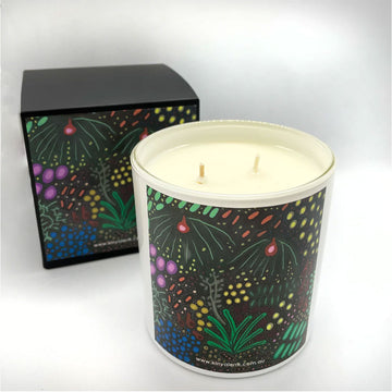 A matching candle and box with a black label printed with coloured plant artwork.