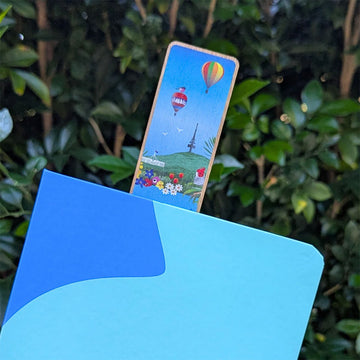 Wooden bookmark with colorful design of Canberra icons and birds on a white background.